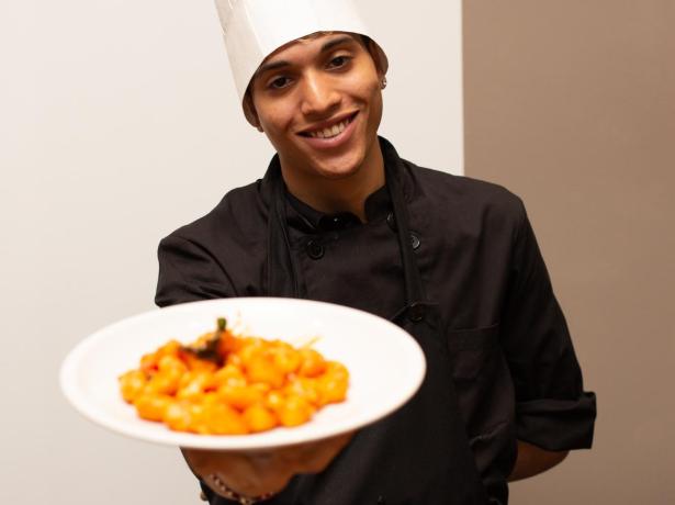 Chef presents tomato gnocchi with a smile.