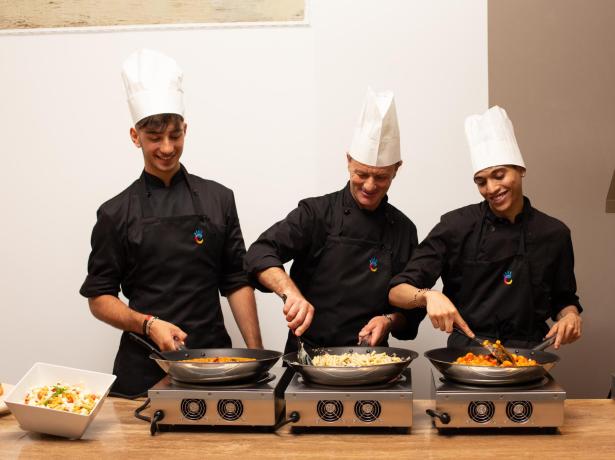 Trois chefs cuisinent de délicieux plats sur des réchauds.