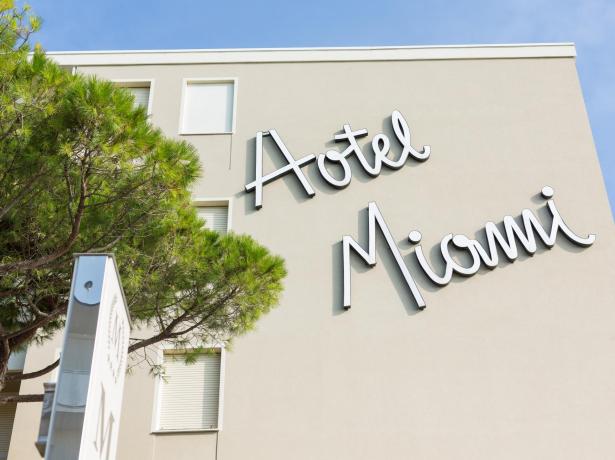 Façade de l'Hôtel Miami avec enseigne stylisée et arbre.